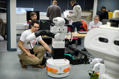 TIAGo robot with one arm interacting with an engineer during the European Robotics League 2018