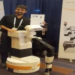 Jordi Pagès of PAL Robotics standing with TIAGo robot at IROS 2017
