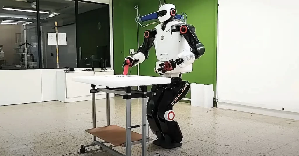 The biped humanoid robot TALOS puts down an object on the table