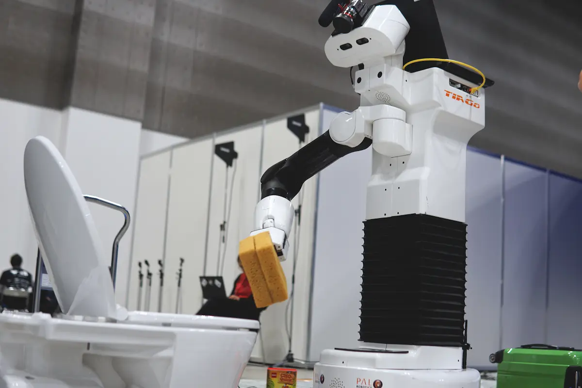 The mobile manipulator robot TIAGo cleaning a toilet
