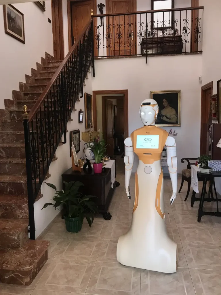 The social robot ARI inside a house next to a stairwell during Project SHAPES