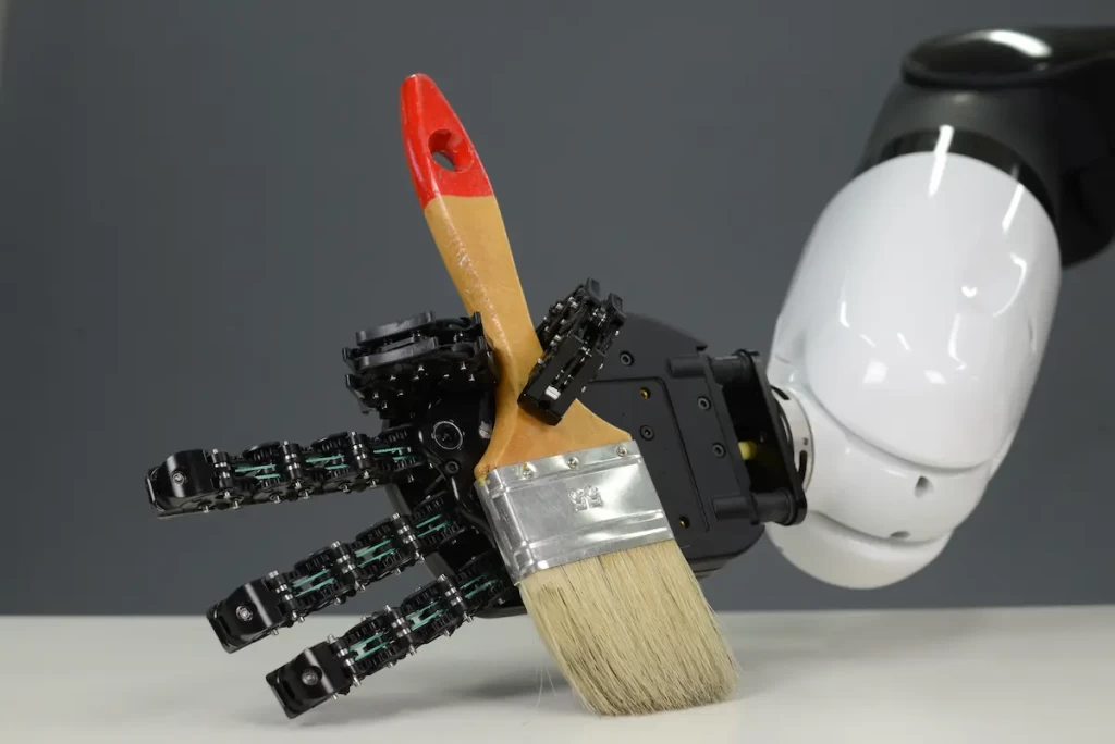 A robotic hand holding a paintbrush during Project NeuTouch
